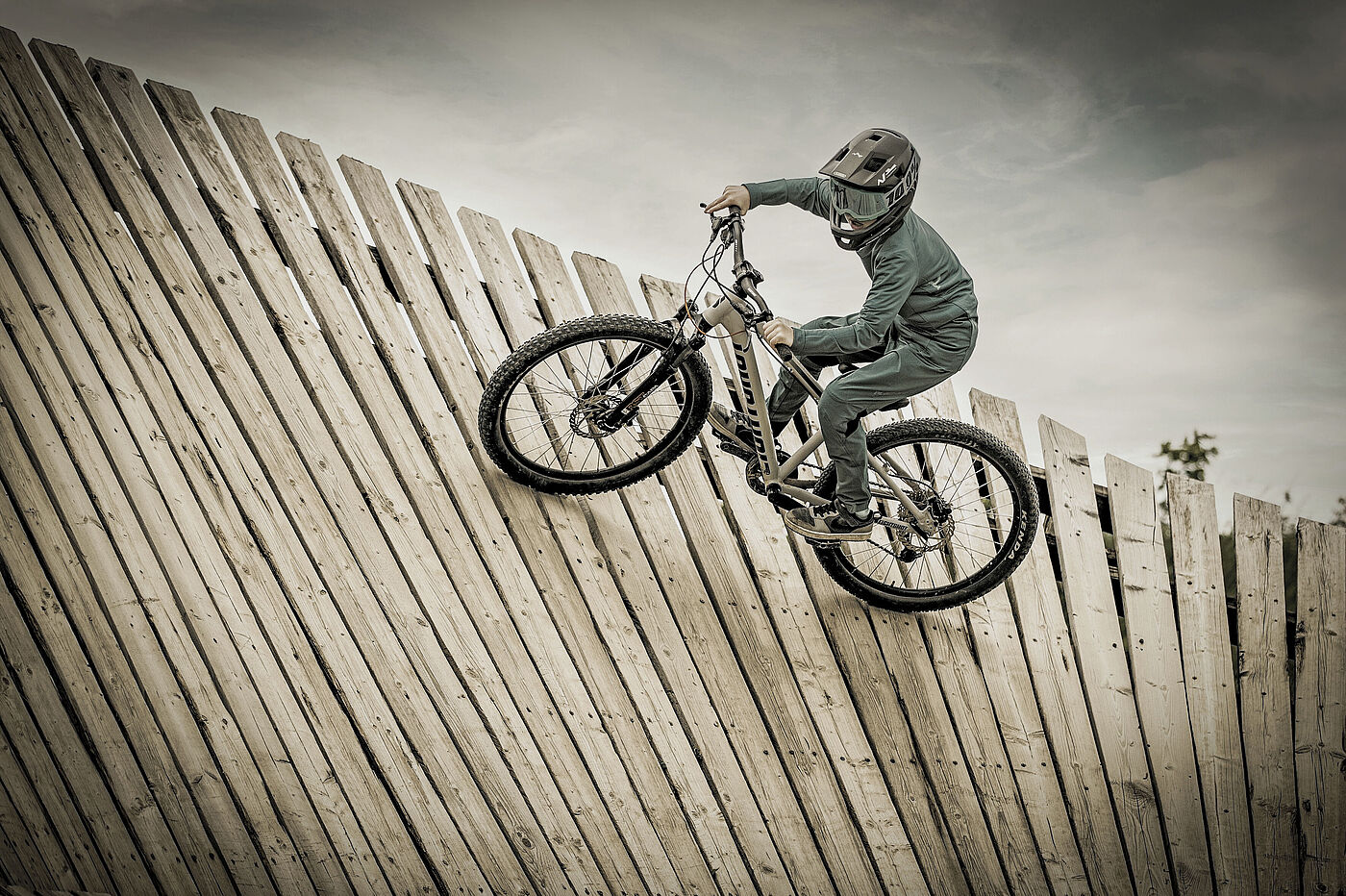 Person mit Fahrrad in einer Bretterpipe